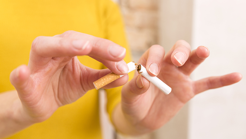 Young woman is breaking a cigarette, quit smoking concept