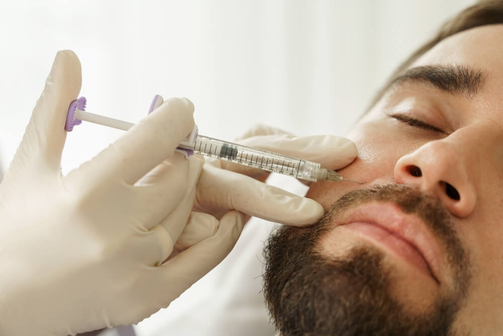 Male client during filler injections in aesthetic medical clinic