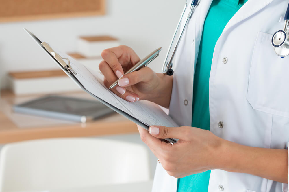 Doctor reviewing medical notes and Rhytidectomy treatment plan for patient’s upcoming facial procedure.