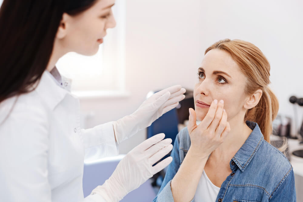 Cosmetic specialist consulting a woman about Rhytidectomy, explaining options for facial rejuvenation treatment.