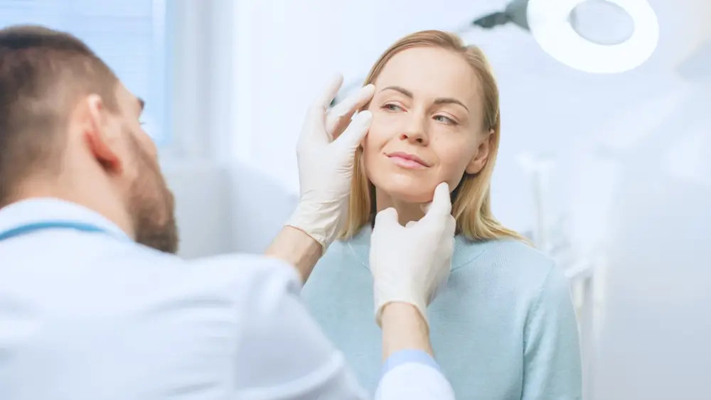 Cosmetic surgeon evaluating patient’s skin and contours before recommending a non-surgical Liquid Facelift treatment.
