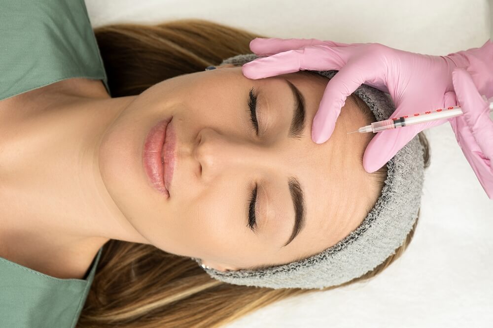 Aesthetic specialist performing Botox Forehead Injection Sites procedure for smooth and rejuvenated skin appearance.