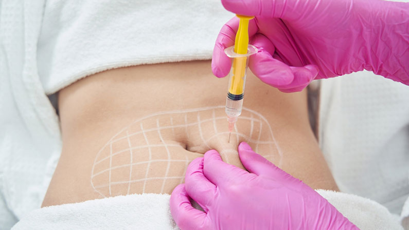 Doctor hands in pink gloves is doing anti cellulite reduction procedure