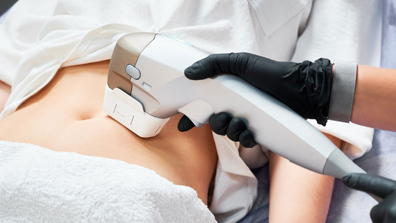 Female patient receiving body tightening and contouring procedure in cosmetology clinic.