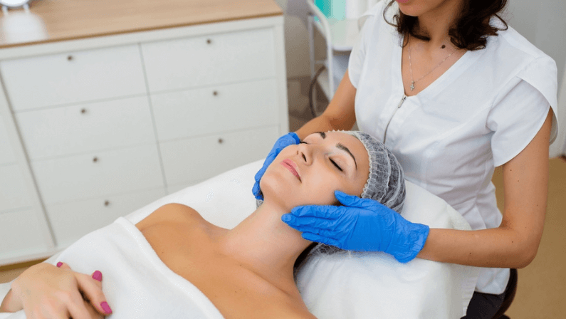Close up of cosmetologist make rejuvenating face procedures for woman client.