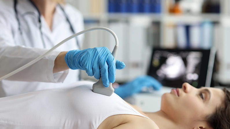 Portrait of doctor makes woman breast ultrasound, treatment before breast augmentation, full checkup in clinic.