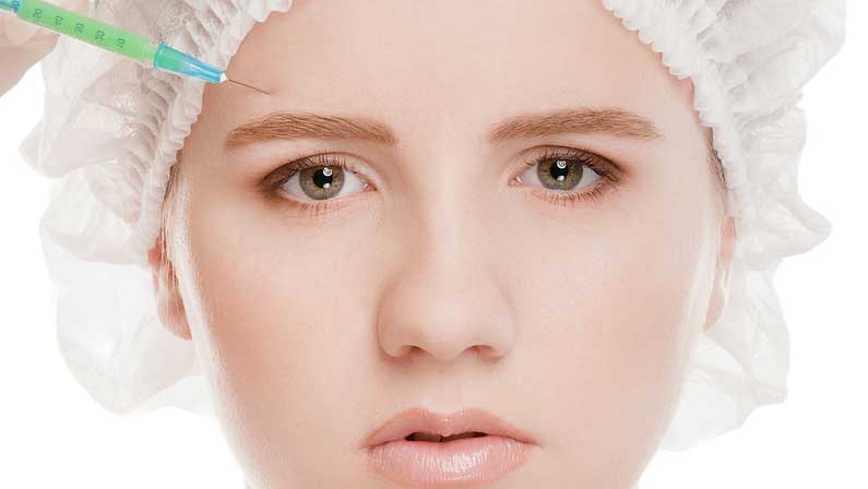 Cosmetic botox injection in the female face. Eye and eyebrow zone. Isolated on white