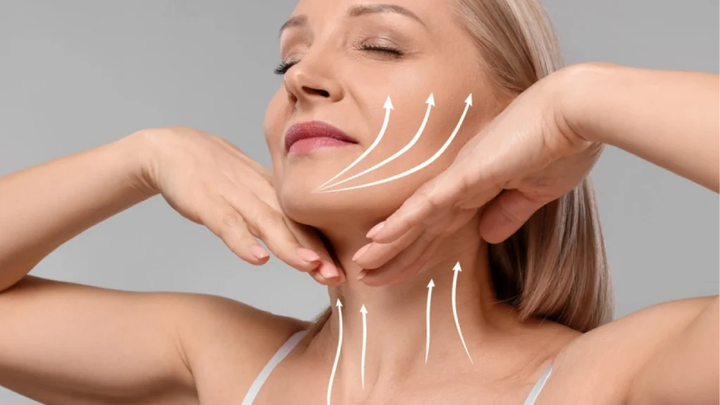 Woman with perfect skin after cosmetic treatment on grey background. Lifting arrows on her neck and face