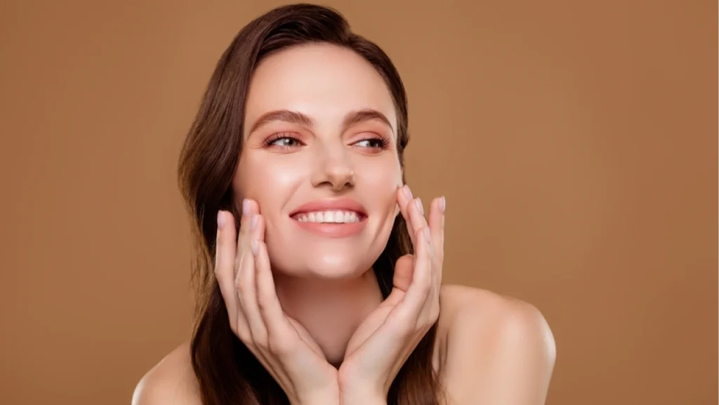 Smiling woman touching her smooth skin after mini facelift, showing natural results and refreshed appearance.