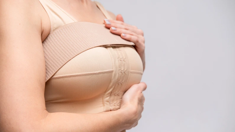 woman patient In post surgical Compression bra, implants stabilizer bra after plastic surgery medical mammoplasty, mastopexy breast enlargement, on white background