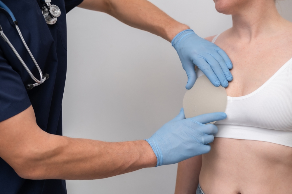 doctor and patient, exam, consultation in clinic office, holding breast enlargement implant in hands