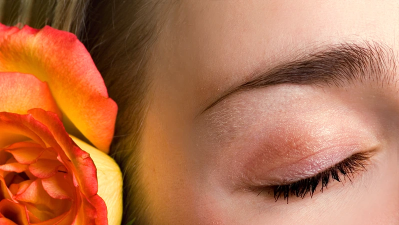 Beautiful female closed eye and rose close-up