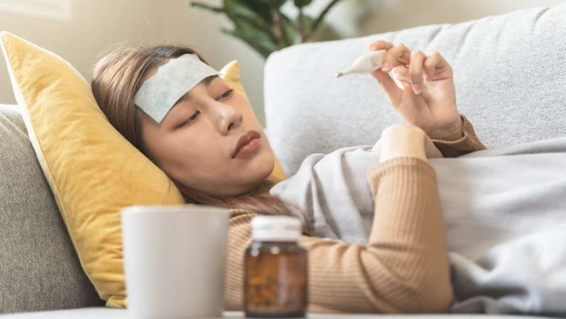 Woman measuring temperature her body on the bed. person got fever lying on the bed