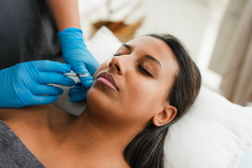 Young woman doing botox treatment inside private medical clinic - Beauty trends and anti aging concept - Focus on face