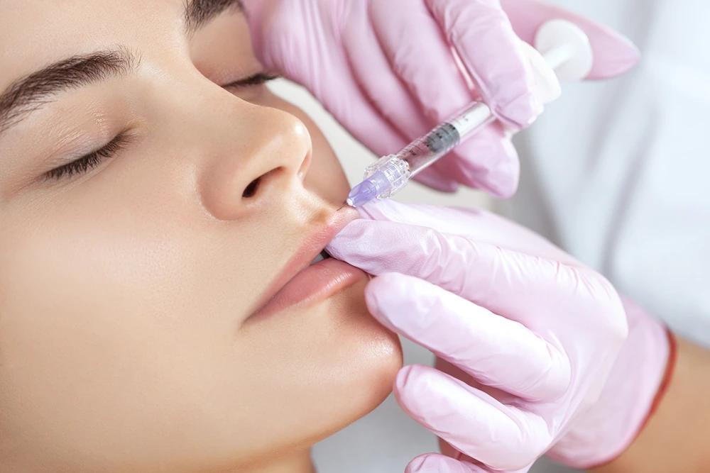 The doctor cosmetologist makes Lip augmentation procedure of a beautiful woman in a beauty salon. Prp therapy, anti wrinkle and aging skin. Cosmetology skin care.